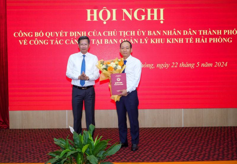 Phó Chủ tịch Thường trực UBND thành phố Lê Anh Quân trao Quyết định và tặng hoa cho đồng chí Nguyễn Quang Minh.