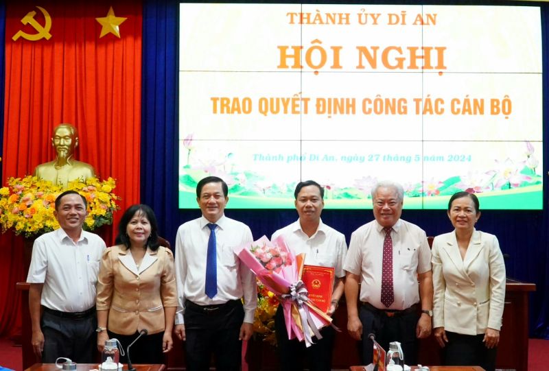 Lãnh đạo TP.Dĩ An, Bình Dương trao quyết định và tặng hoa chúc mừng cán bộ được bổ nhiệm. Ảnh: Đỗ Trọng