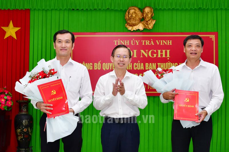 Đồng chí Nguyễn Văn Hiếu, Trưởng Ban Tổ chức Tỉnh ủy Trà Vinh trao quyết định và tặng hoa chúc mừng 02 đồng chí Nguyễn Văn Tâm (phải) và đồng chí Nguyễn Văn Nhủ (trái).