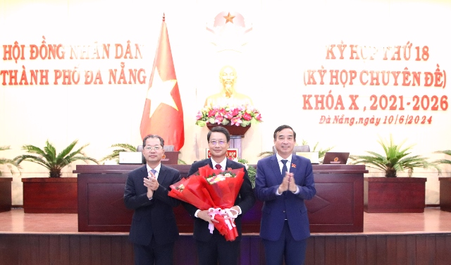 Ông Nguyễn Văn Quảng (bên trái), Bí thư Thành ủy Đà Nẵng và ông Lê Trung Chinh, Chủ tịch UBND TP Đà Nẵng tặng hoa chúc mừng ông Ngô Xuân Thắng