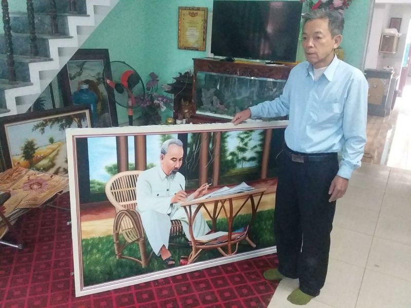 Nghệ nhân Nguyễn Cao Bính bên những bức tranh thêu chân dung Bác Hồ