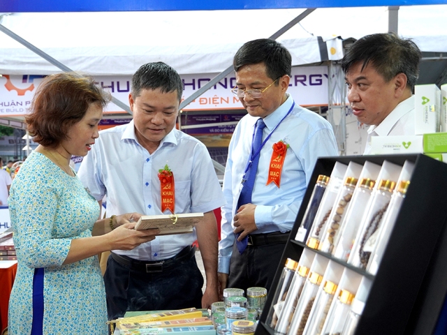 Phó Chủ tịch UBND tỉnh và các đại biểu tham quan gian hàng trưng bày, giới thiệu sản phẩm tại hội chợ.