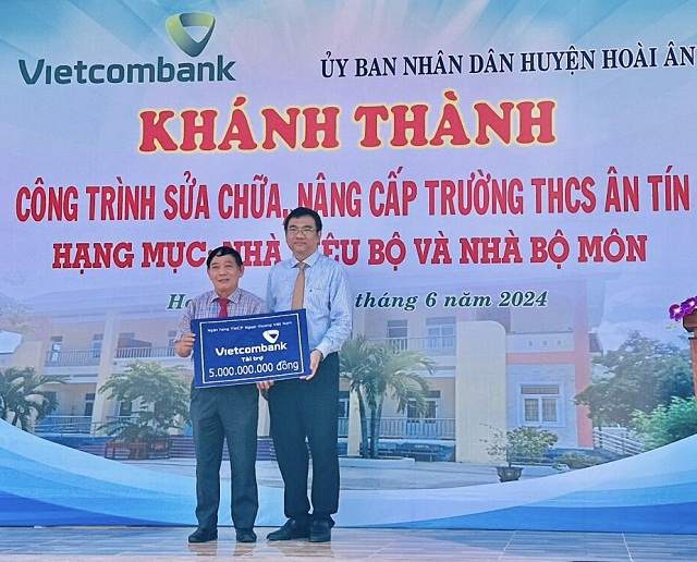 Ông Nguyễn Quốc Việt (bên phải) trao bảng tài trợ cho địa phương. Ảnh: H. Nghị.
