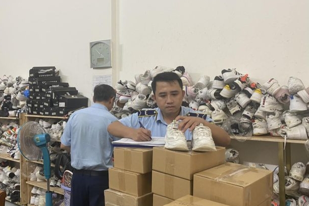 Cán bộ Cục Quản lý thị trường Đắk Lắk thực hiện kiểm tra một cơ sở kinh doanh giày dép vi phạm được phát hiện thông qua nền tảng TMĐT