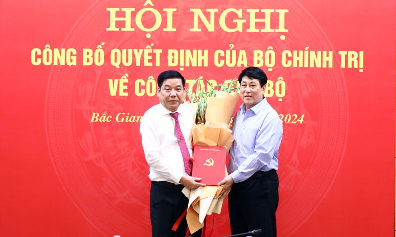 Đồng chí Lương Cường trao Quyết định và tặng hoa chúc mừng đồng chí Nguyễn Văn Gấu.