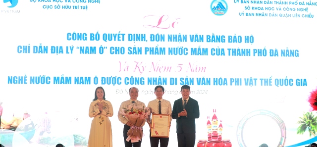 Phó Cục trưởng Cục Sở hữu trí tuệ Trần Lê Hồng (bên phải) cùng Phó Chủ tịch UBND thành phố Nguyễn Thị Anh Thi (bên trái) trao văn bằng bảo hộ và hoa chúc mừng cho lãnh đạo UBND quận Liên Chiểu
