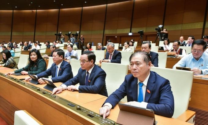 Các đại biểu Quốc hội bấm nút thông qua Nghị quyết kỳ họp 7, sáng 29/6. Ảnh: Hoàng Phong