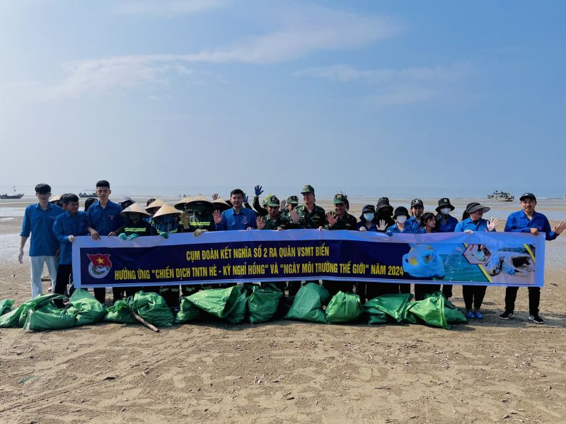 Cán bộ, chiến sĩ Đồn Biên phòng Trà Cổ phối hợp với người dân tổ chức dọn vệ sinh môi trường trên bãi biển.