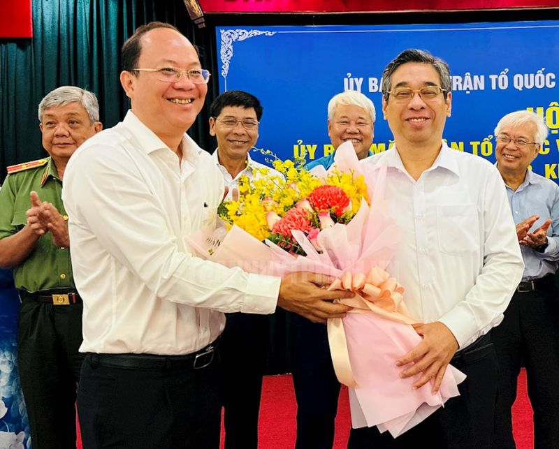 Phó Bí thư Thường trực Thành ủy TP.HCM Nguyễn Hồ Hải trao hoa chúc mừng ông Nguyễn Phước Lộc. Ảnh: PHƯƠNG ĐẶNG