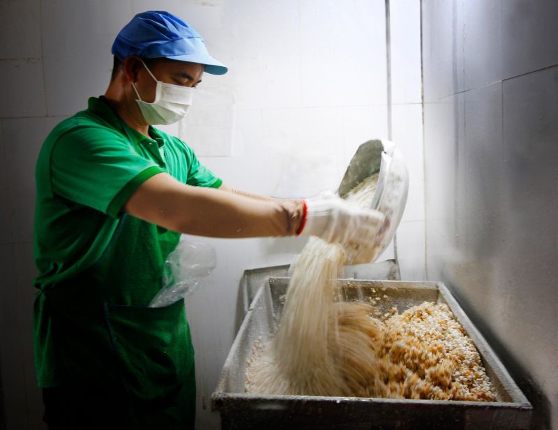 Công nhân tại xưởng sản xuất đang phối trộn các nguyên liệu chính của bánh cáy
