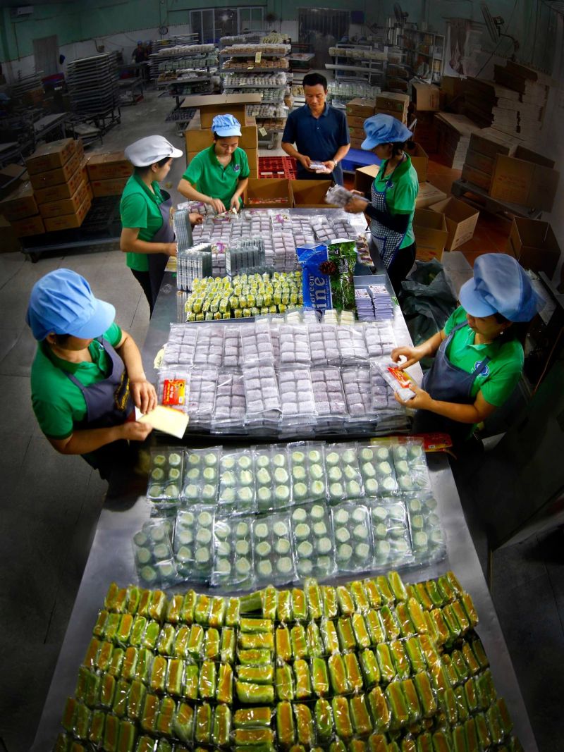Ông Trần Văn Đức đang kiểm tra khâu đóng gói các bánh kẹo tại xưởng sản xuất