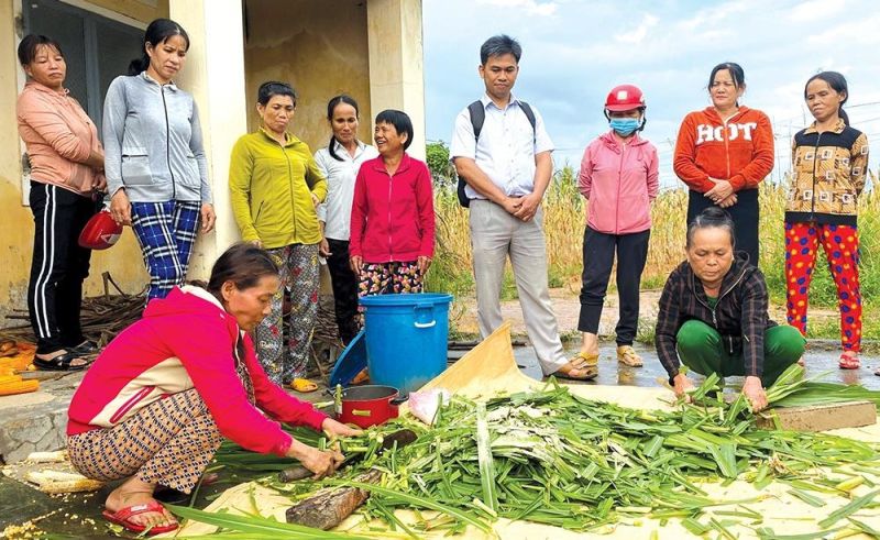 Chị Lê Thị Hà Công (ngồi bên trái) cùng các học viên lớp đào tạo nghề chăn nuôi gia súc đang thực hành cách ủ thức ăn cho bò.