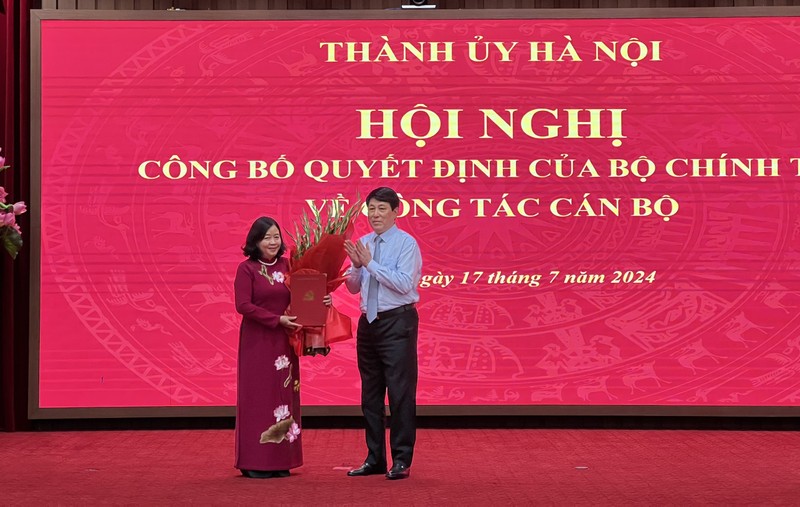 Bà Bùi Thị Minh Hoài, tân Bí thư Thành ủy Hà Nội (trái) nhận hoa chúc mừng từ Thường trực Ban Bí thư Lương Cường