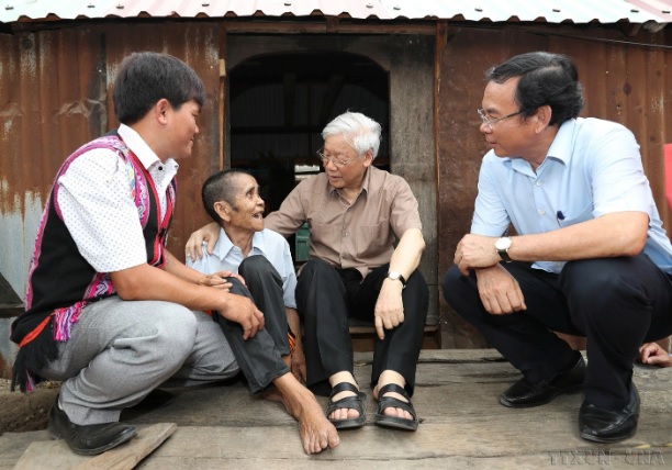 Tổng Bí thư Nguyễn Phú Trọng thăm, tặng quà thương binh Đinh Phi và vợ là Đinh Brat, hộ gia đình chính sách có hoàn cảnh đặc biệt khó khăn ở làng Tung Ke 2, xã Ayun, huyện Chư Sê, tỉnh Gia Lai. Ảnh: Trí Dũng - TTXVN