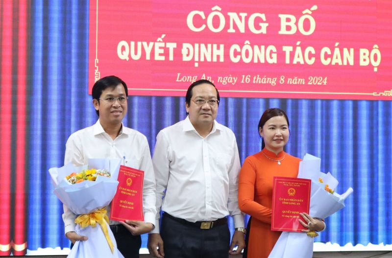 Ông Nguyễn Tấn Lực và bà Nguyễn Thúy Huyên nhận quyết định và hoa chúc mừng