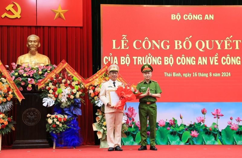 Thiếu tướng Nguyễn Ngọc Lâm, Thứ trưởng Bộ Công an trao Quyết định và tặng hoa chúc mừng Đại tá Trần Xuân Ánh