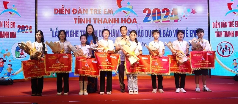 Phó Chủ tịch UBND tỉnh Đầu Thanh Tùng và Giám đốc Sở Lao động, Thương binh và Xã hội Vũ Thị Hương trao cờ lưu niệm cho các đơn vị tham gia diễn đàn.