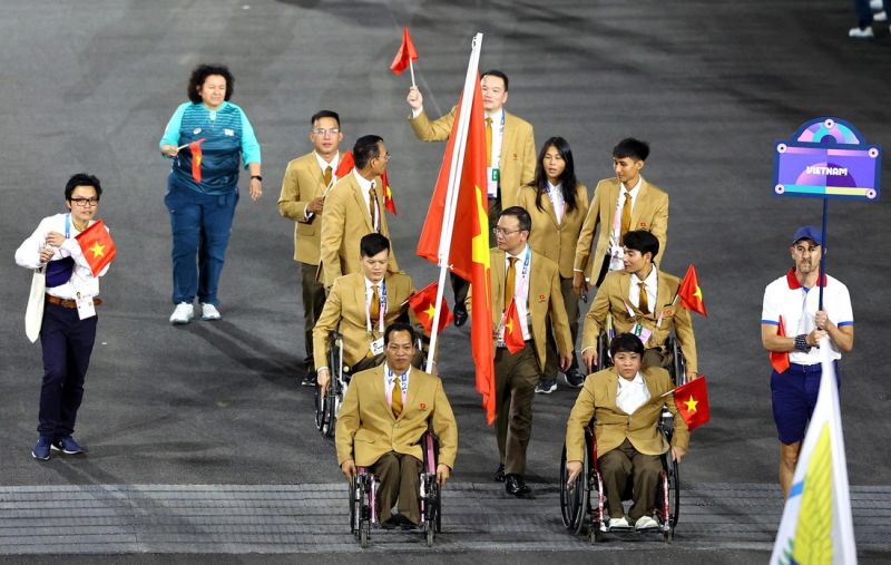 Đoàn thể thao Việt Nam diễu hành trong lễ khai mạc Paralympic 2024 với người cầm cờ là đô cử Lê Văn Công (trái, hàng đầu) - Ảnh: REUTERS