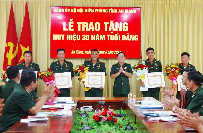 Thượng tá Nguyễn Văn Hiệp, Bí thư Đảng ủy, Chính ủy Bộ đội Biên phòng tỉnh trao huy hiệu 30 năm tuổi Đảng cho các đảng viên