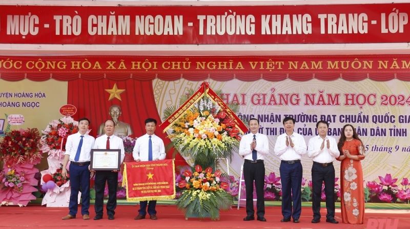 Ông Đỗ Minh Tuấn, Phó Bí thư Tỉnh ủy, Chủ tịch UBND tỉnh Thanh Hóa cùng đại diện lãnh đạo Sở GD&ĐT, huyện Hoằng Hóa tặng hoa chúc mừng cán bộ, giáo viên, học sinh Trường THCS Hoằng Ngọc.