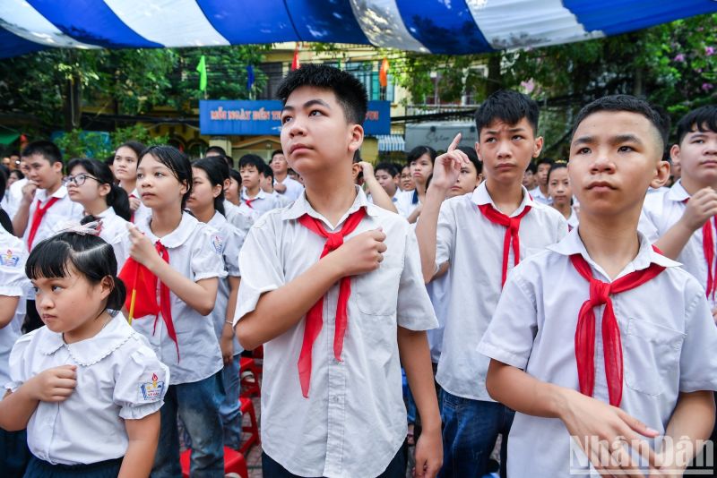 Chỉ ít phút sau, tiếng nhạc bản Tiến quân ca vang lên. Khối các học sinh bình thường bắt đầu cất tiếng hát. Nửa còn lại, những học sinh 