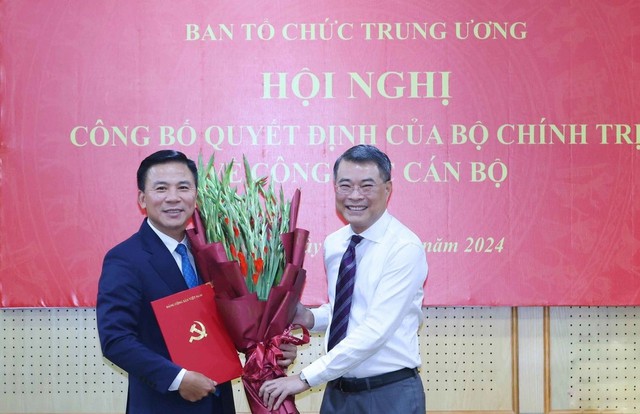 Trưởng Ban Tổ chức Trung ương Lê Minh Hưng trao quyết định và tặng hoa chúc mừng tân Phó Trưởng Ban Tổ chức Trung ương Đỗ Trọng Hưng. Ảnh: TN