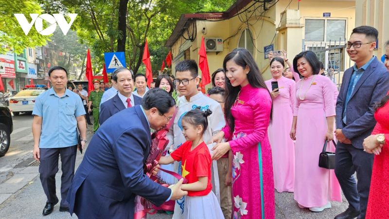 Thầy và trò Trường Phổ thông cơ sở Nguyễn Đình Chiểu đón và tặng hoa Thủ tướng Phạm Minh Chính.