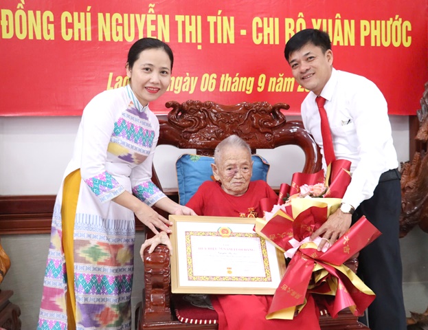 Đồng chí Hồ Thị Thu Hằng, UVBTV, Trưởng Ban Tổ chức Huyện ủy trao Huy hiệu 75 năm tuổi Đảng và đồng chí Trần Đình Dũng- Bí thư Đảng ủy Thị Trấn Lao Bảo