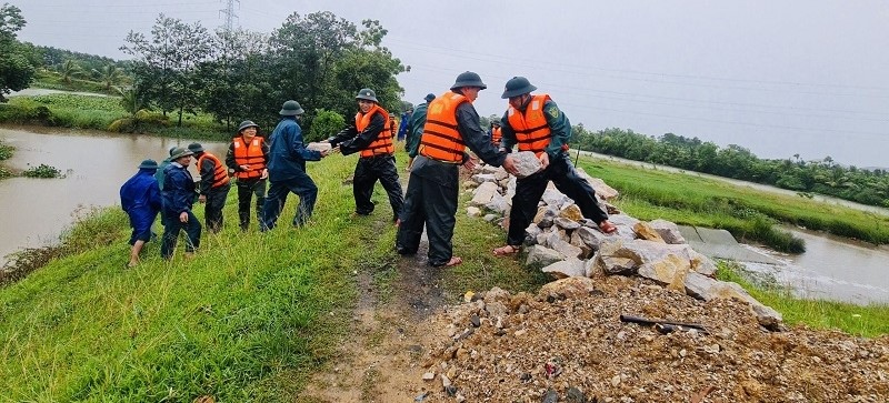 Cán bộ, chiến sĩ và lực lượng dân quân tự vệ các xã gia cố kênh mương, chủ động ứng phó với hoàn lưu mưa lũ sau bão số 3.