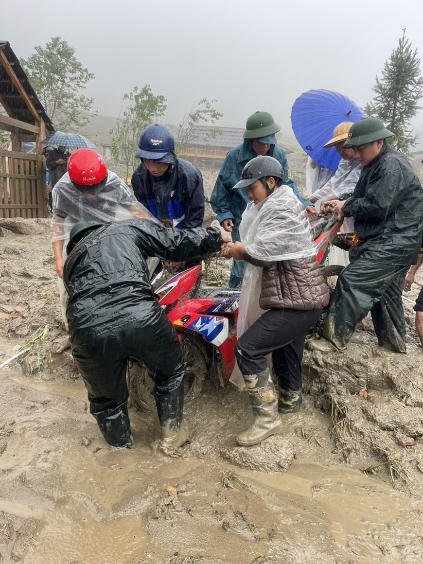 Lực lượng vũ trang Lào Cai tham gia giúp dân đưa phương tiện qua khu vực nguy hiểm.