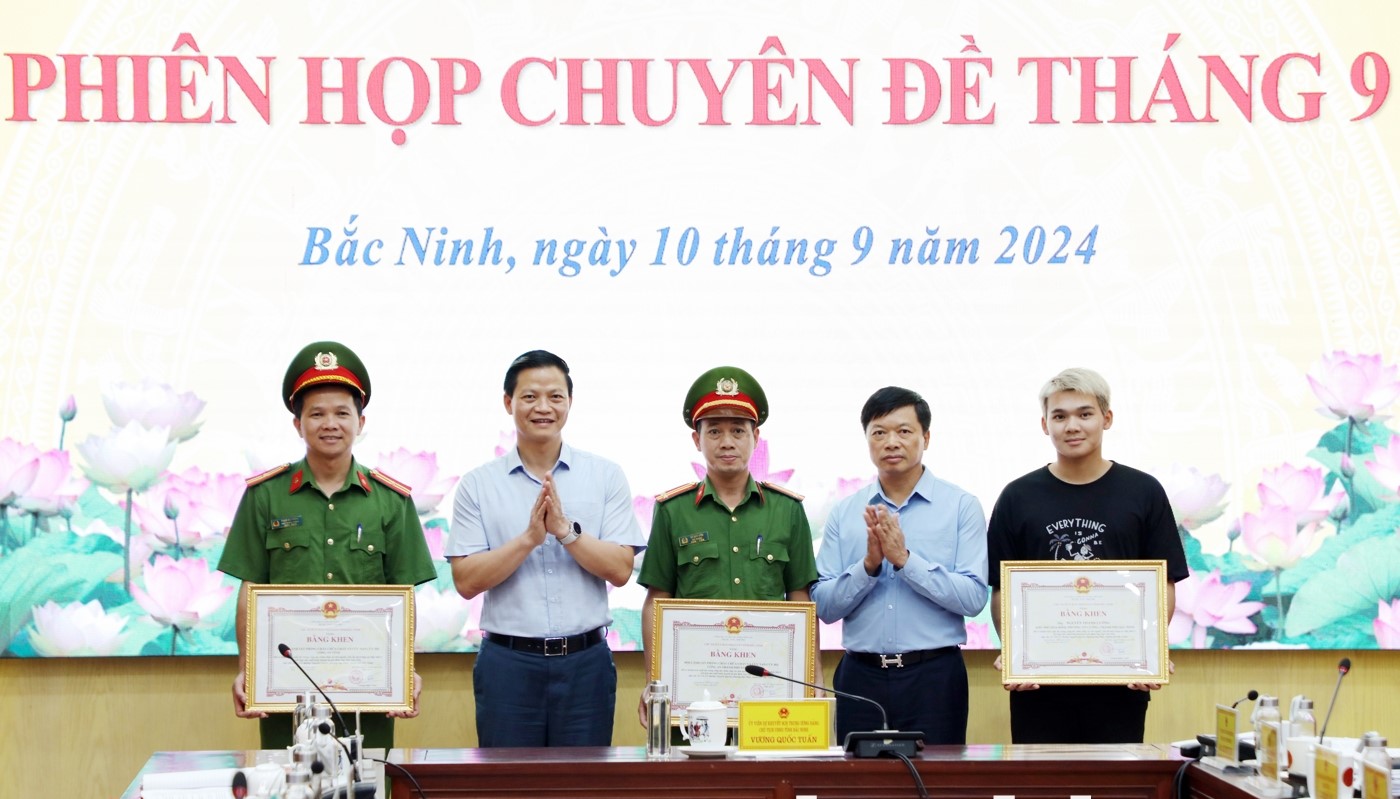 Chủ tịch UBND tỉnh Vương Quốc Tuấn (thứ 2 từ trái qua) và Phó Chủ tịch Thường trực UBND tỉnh Đào Quang Khải (thứ 2 từ phải qua) trao Bằng khen cho các tập thể, cá nhân có thành tích xuất sắc trong công tác chữa cháy và cứu người, cứu tài sản trong vụ cháy hộ gia đình ông Ngô Văn Tiến.