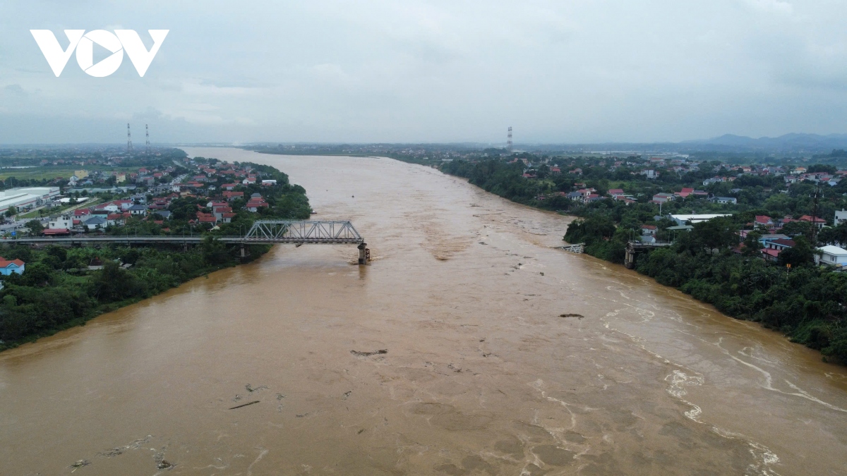 Thời điểm cầu Phong Châu bị sập có một số phương tiện đang di chuyển. Phía dưới nước sông Hồng đang dâng cao cuồn cuộn.