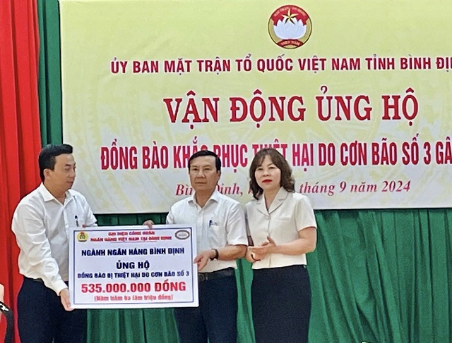 Đại diện Ngân hàng Nhà nước, Chi nhánh Bình Định trao tiền ủng hộ. Ảnh: H.P