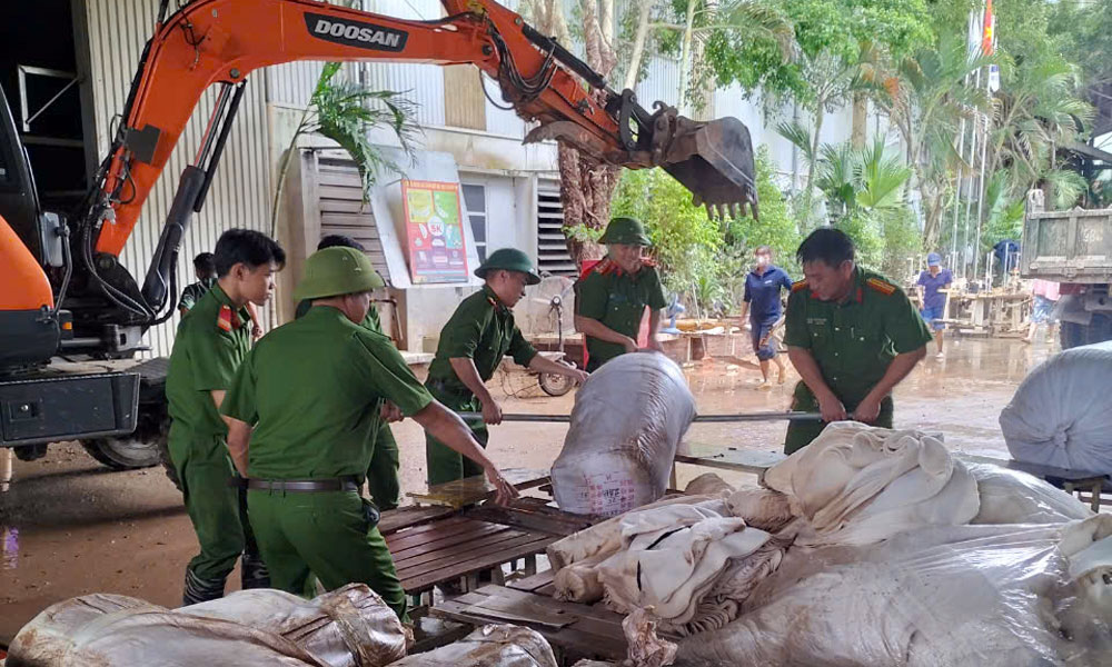 Cán bộ Công an huyện Lục Ngạn tham gia hỗ trợ thu dọn, vệ sinh môi trường sau khi nước rút tại thị trấn Chũ. Thực h