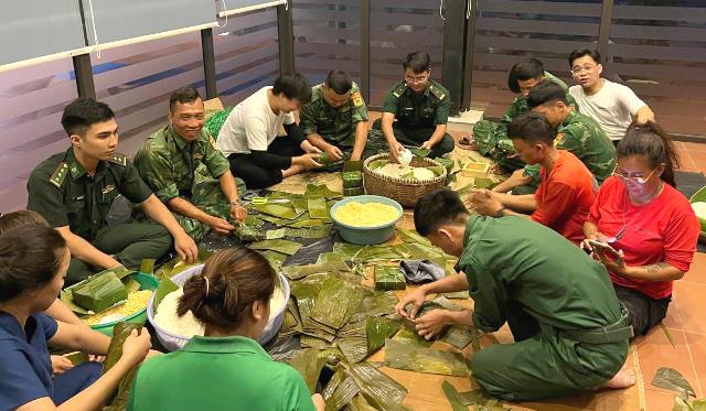 Cán bộ, chiến sĩ Biên phòng cửa khẩu cảng Đà Nẵng và các cô giáo Nhóm trẻ Ngôi nhà xanh của bé gói bánh chưng gửi tặng bà con nhân dân vùng lũ phía Bắc. Ảnh: Trúc Hà