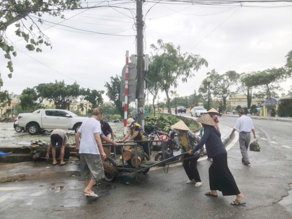 Người dân thị trấn Quảng Hà (huyện Hải Hà) tham gia dọn cây đổ sau cơn bão số 3. Ảnh: Hữu Việt