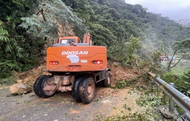 Lực lượng chức năng huy động máy móc dời dọn đất đá, cây cối bị sạt lở trên tuyến Quốc lộ 8A.