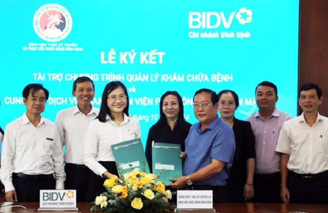 Lãnh đạo BIDV – Chi nhánh Bình Định (thứ 3 từ trái qua) và lãnh đạo Bệnh viện Y học cổ truyền và Phục hồi chức năng Bình Định (thứ 5 từ trái qua) tại Lễ ký kết “Chương trình quản lý khám chữa bệnh và cung ứng dịch vụ thanh toán viện phí không dùng tiền mặt”. Ảnh: BIDV BĐ