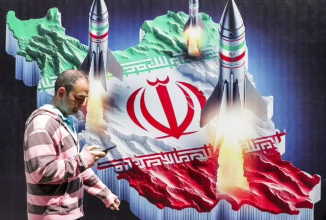 Một người dân đi ngang qua áp phích mô tả hình ảnh Iran phóng tên lửa, vào ngày 15/4/2024. Ảnh: Getty Images Một người dân đi ngang qua áp phích mô tả hình ảnh Iran phóng tên lửa, vào ngày 15/4/2024. Ảnh: Getty Images