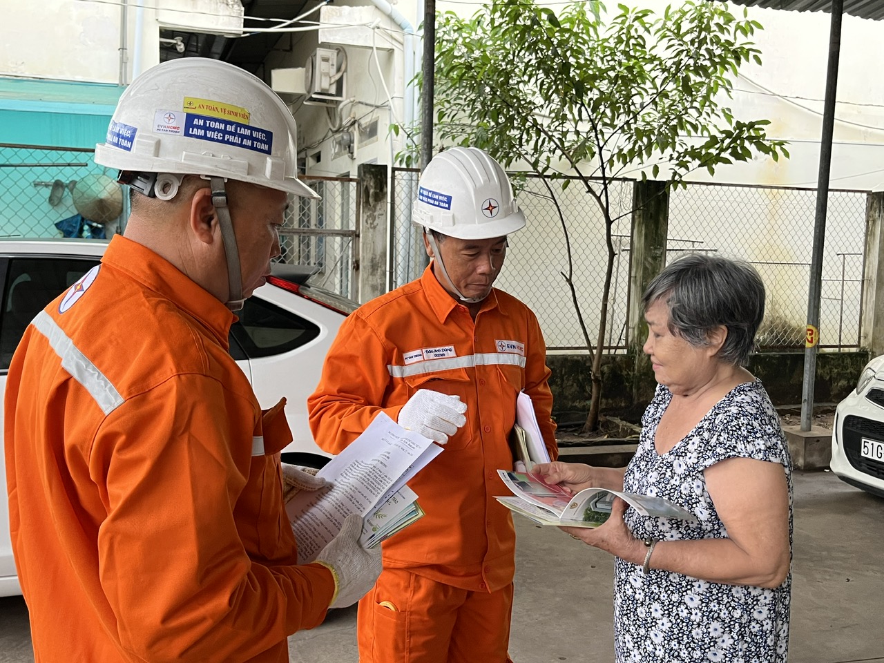 Nhân viên Công ty Điện lực TP. Hồ Chí Minh tuyên truyền về giá điện cho người thuê trọ cho một chủ phòng trọ trên địa bàn quận 7