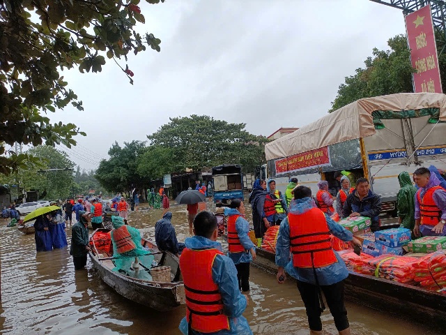 Chính quyền địa phương huy động thuyền chở nhu yếu phẩm cứu trợ đến tay người dân vùng lũ.