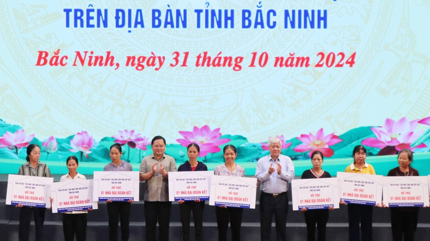 Chủ tịch Uỷ ban Trung ương MTTQ Việt Nam Đỗ Văn Chiến (thứ 4 từ phải qua), Bí thư Tỉnh uỷ Nguyễn Anh Tuấn (thứ 4 từ trái qua) trao biển xây dựng nhà đại đoàn kết cho các hộ gia đình.