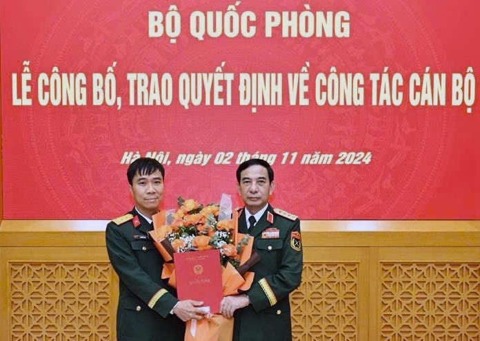 Đại tướng Phan Văn Giang, Ủy viên Bộ Chính trị, Phó bí thư Quân ủy Trung ương, Bộ trưởng Bộ Quốc phòng trao quyết định cho Trung tá Nguyễn Đạt.