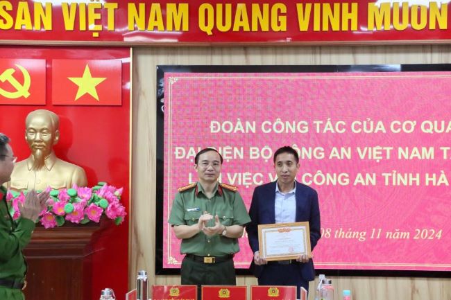 Đại tá Nguyễn Xuân Thao tặng bằng khen cho thành viên đoàn công tác của Cơ quan đại diện Bộ Công an Việt Nam tại Lào.