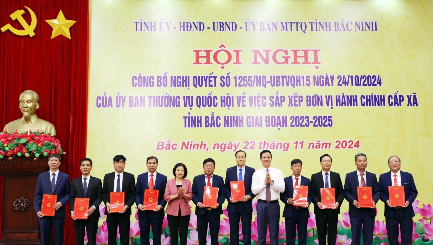 Phó Bí thư Thường trực Tỉnh ủy, Chủ tịch HĐND tỉnh Nguyễn Hương Giang (thứ 5 từ trái qua) và Chủ tịch UBND tỉnh Vương Quốc Tuấn (thứ 5 từ phải qua) trao Nghị quyết của Ủy ban Thường vụ Quốc hội cho các xã, phường, thị trấn.