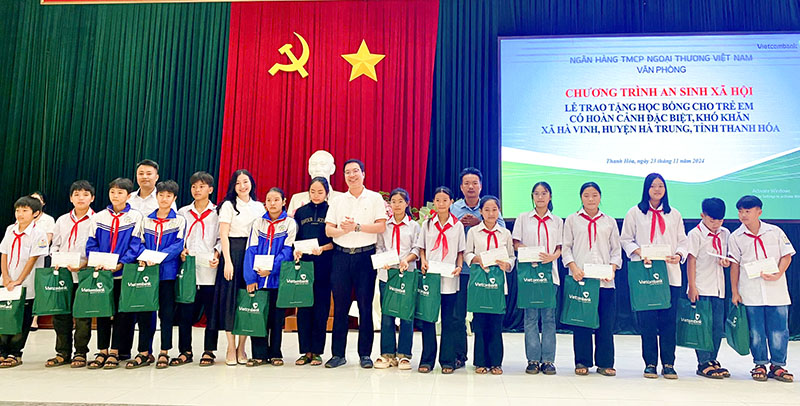 Đại diện lãnh đạo Văn phòng Trụ sở chính - Ngân hàng Vietcombank tặng quà cho các em học sinh tại huyện Hà Trung.