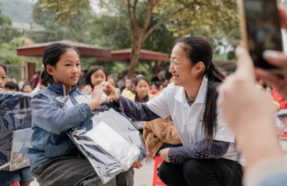 Bà Rika Yamamoto, Giám đốc Peace Winds Nhật Bản tặng cặp sách cho em nhỏ.