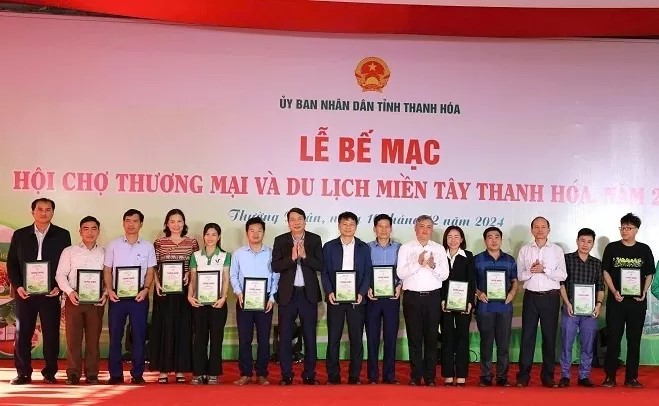 an tổ chức Hội chợ Thương mại và Du lịch miền Tây Thanh Hóa trao giấy chứng nhận cho các đơn vị đã có đóng góp vào sự thành công của hội chợ.