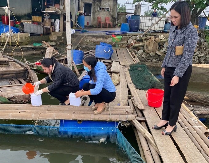 Cơ quan chức năng tiến hành lấy mẫu nước tại hồ nuôi có cá chim chết để gửi đi phân tích.