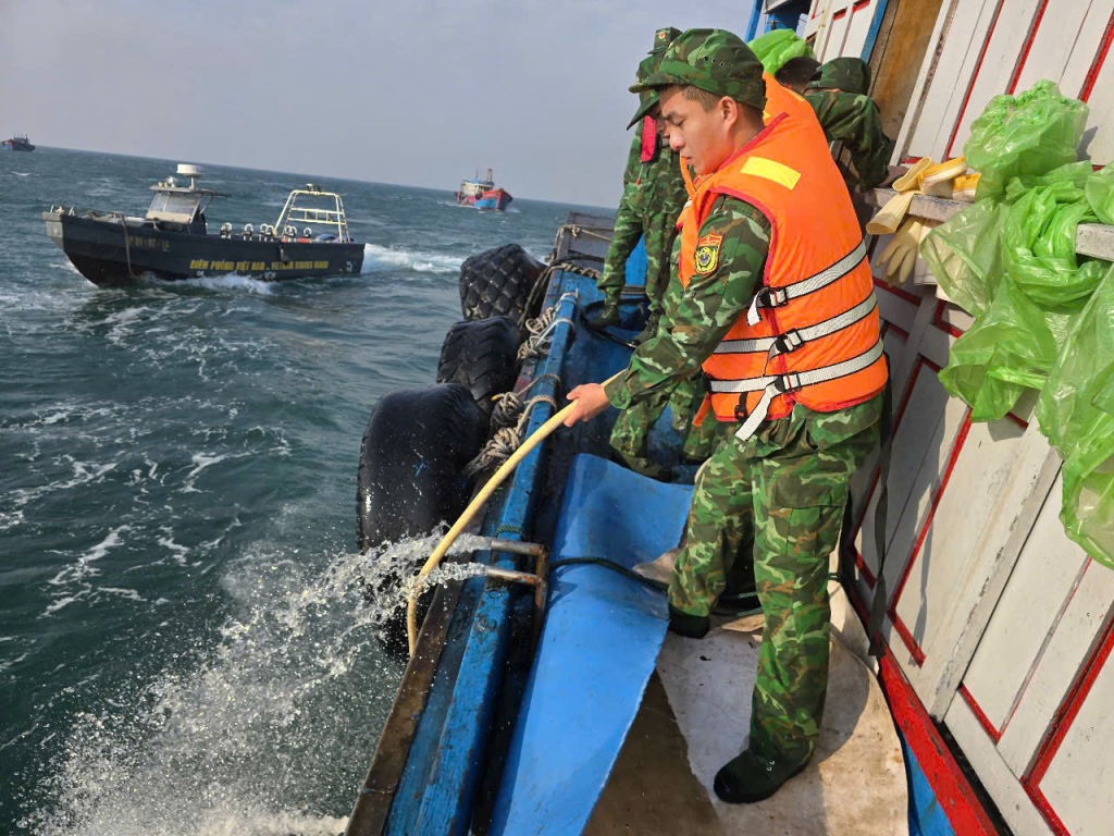 Lực lượng cứu hộ tiến hành tháo bớt nước trong khoang máy và lai dắt tàu cá bị nạn vào bờ an toàn.